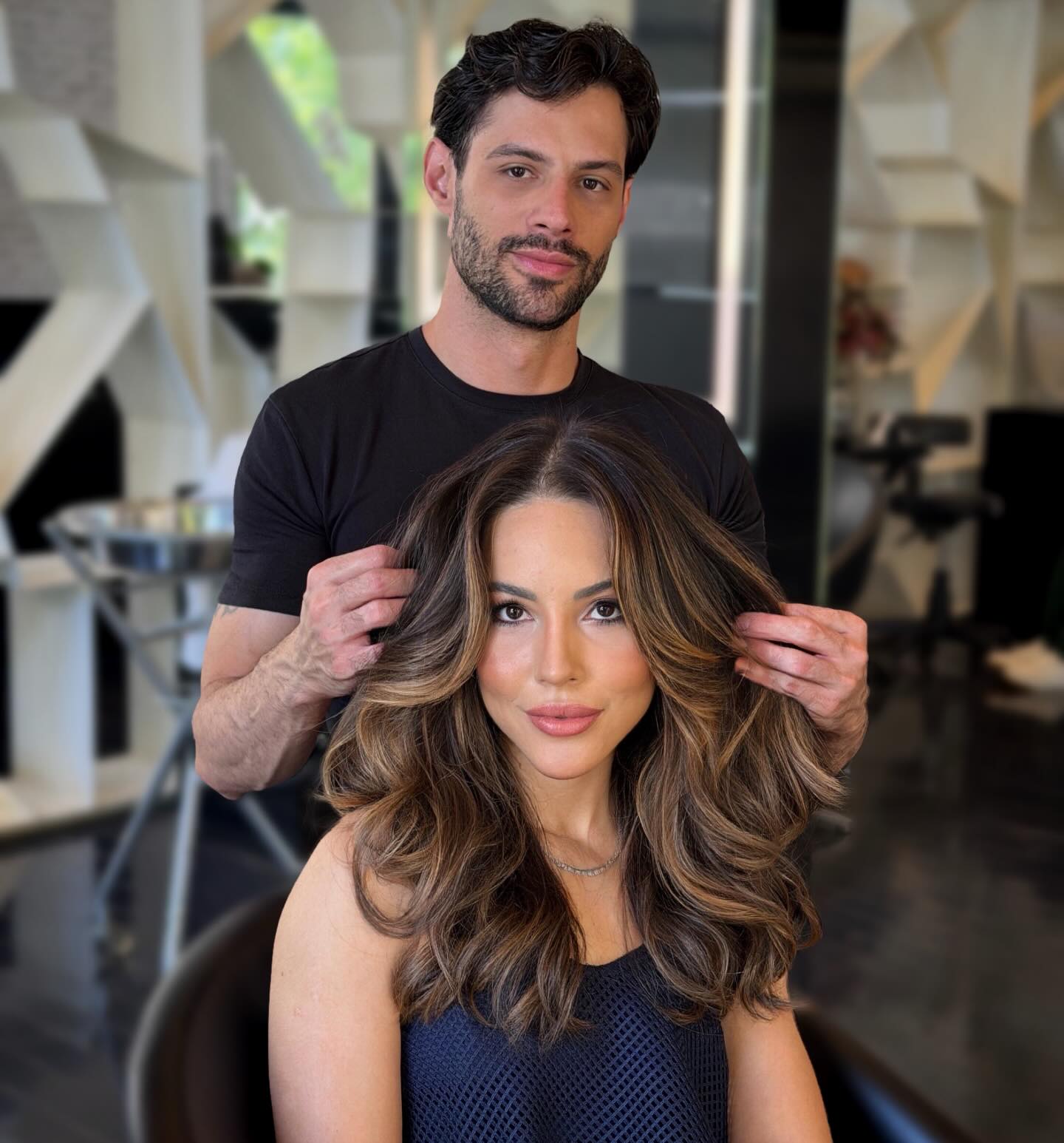 Jheison Oliveira, hair stylist, ao lado de cliente com cabelo finalizado no Studio W